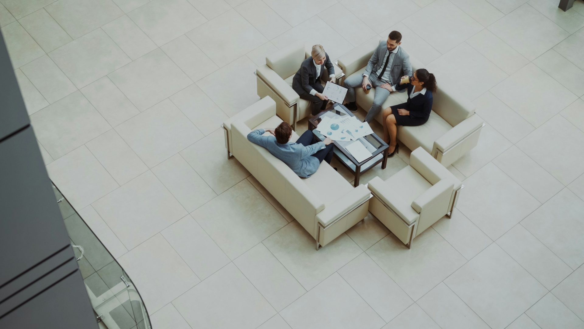 Business people meeting on sofas in a modern lobby.